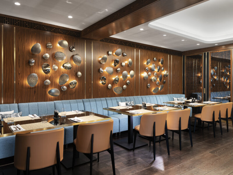 Топло ресторантско осветление с меки тонове, създаващо приветлива атмосфера.